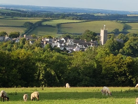 Dartmoor village with hills and church tower with flag