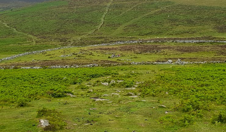 Dartmoor prehistoric settlement of Grimspound with tor behind