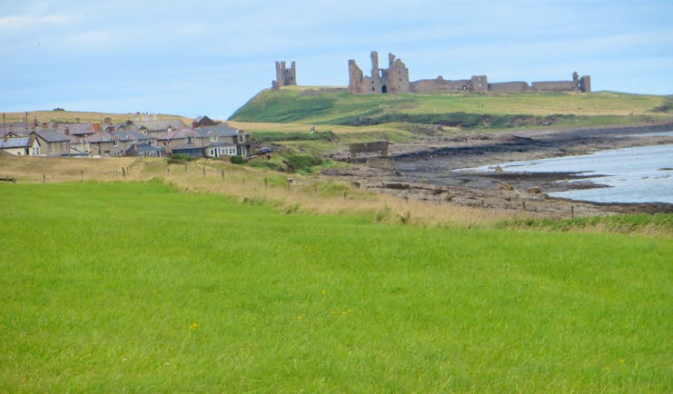 Ruins of castle on hill by sea Northumberland