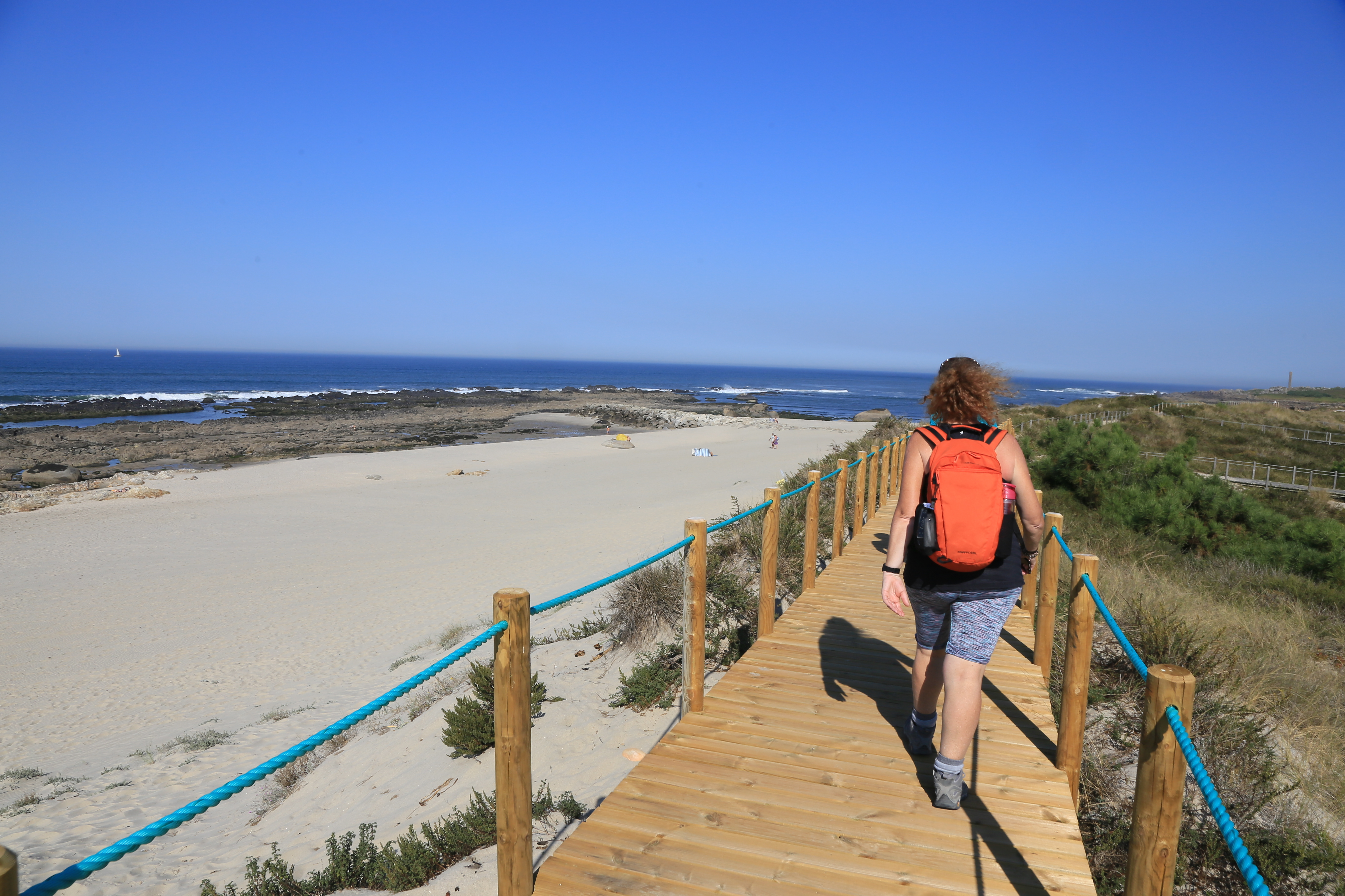 Walker on wooden walkway over sandy beach