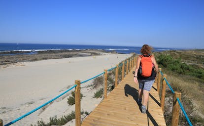 Walker on wooden walkway over sandy beach