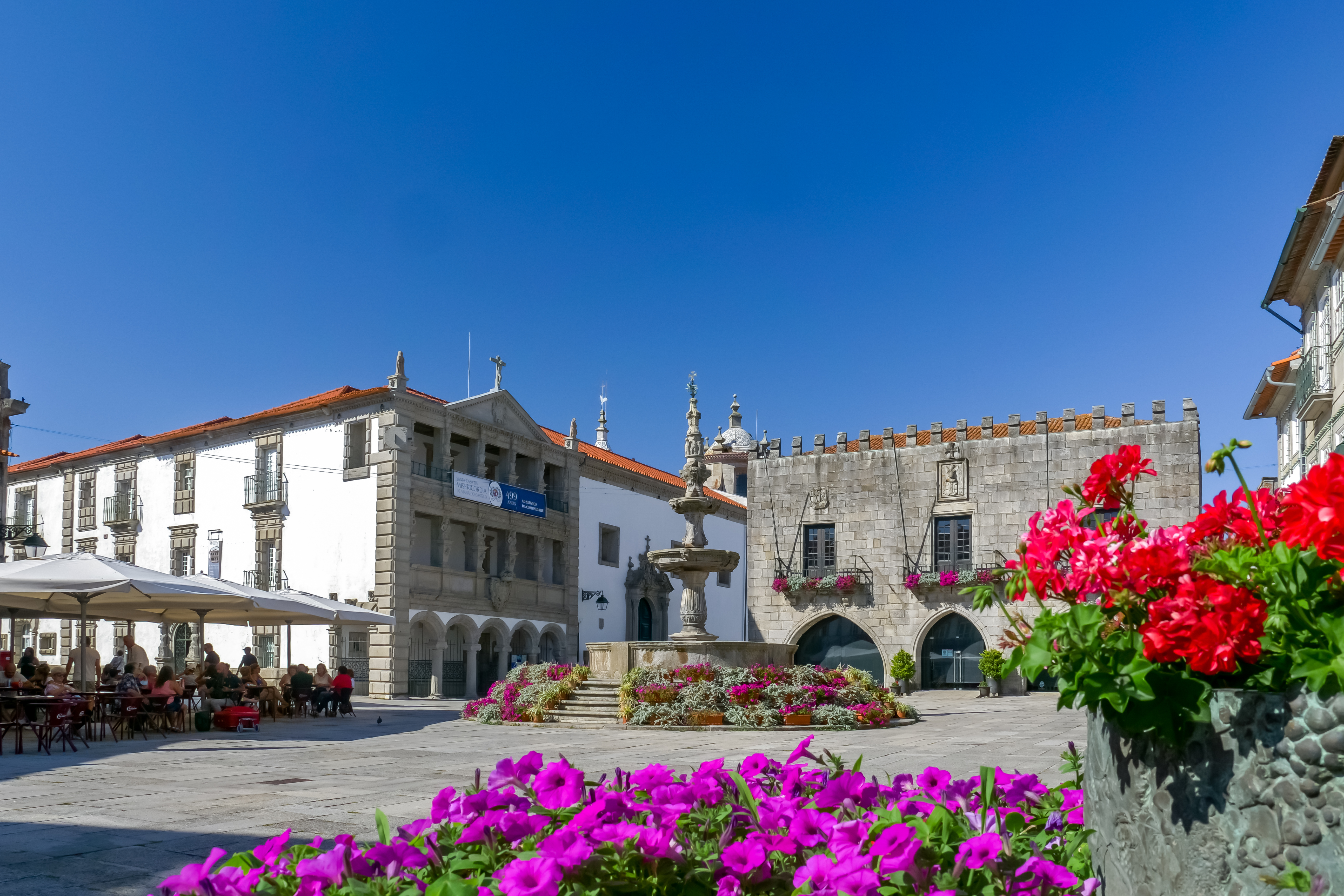 Low old buildings in town square with flowers