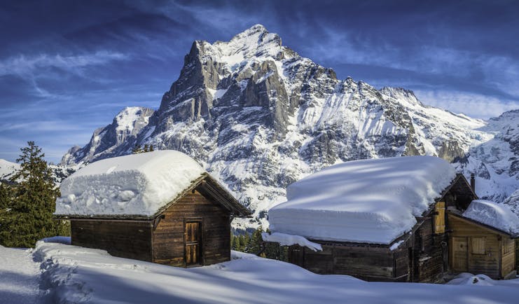 Alpine wooden houses with thick snow on roof at Grindelwald