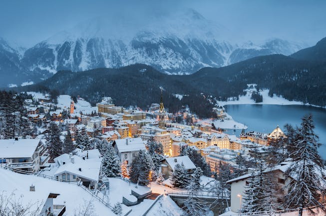 Dusk winter view of St Moritz town, lake and mountains